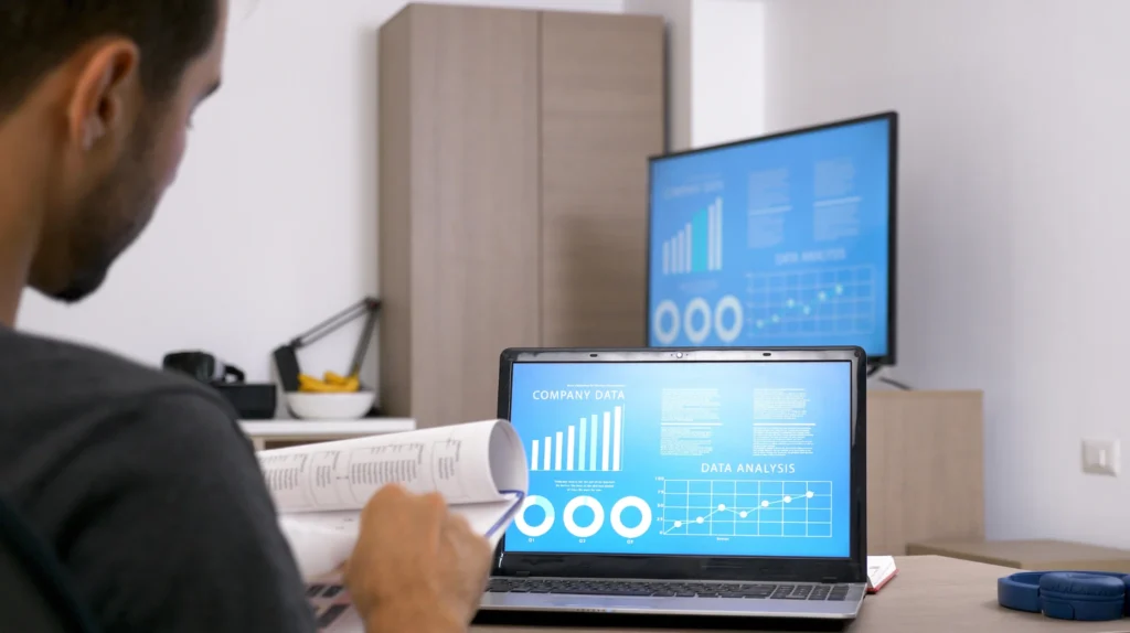 A marketer assesses detailed reports on his laptop