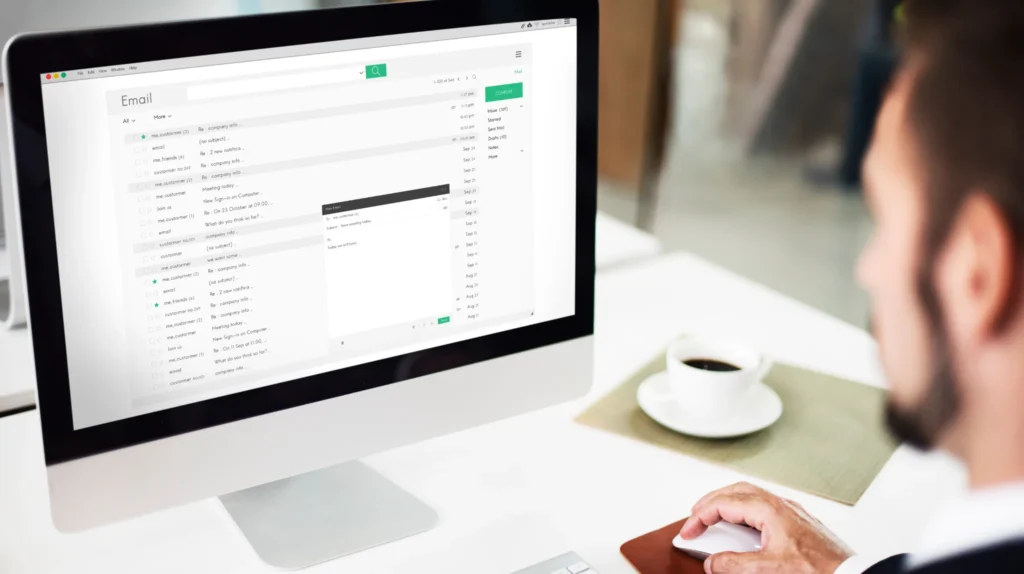An email marketer works on his desktop